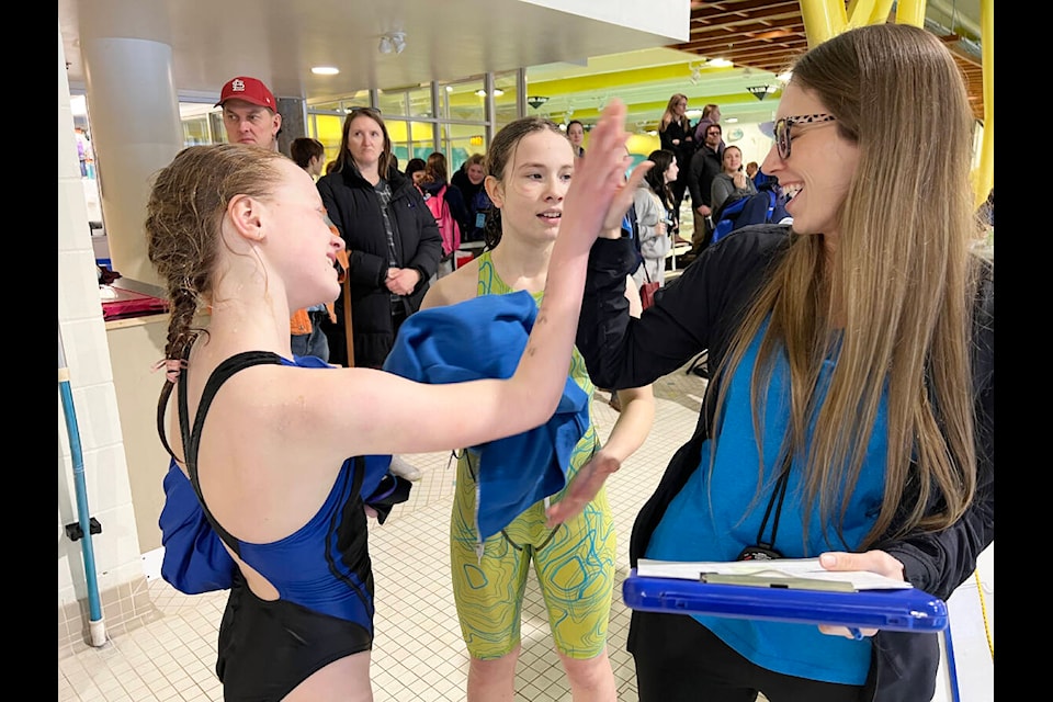 Williams Lake Blue Fins Club assistant head coach Amanda Nemeth high fives competitors Sunday morning. (Angie Mindus photo - Williams Lake Tribune)