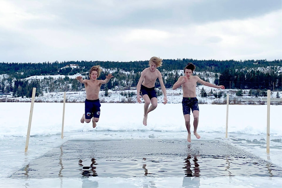 Linden Pinette, from left, Chaz Lucas, Carter Krueger jump in at the Freezin’ for a Reason polar bear plunge in Williams Lake at Scout Island on Feb. 4, 2023. (Ruth Lloyd photo - Williams Lake Tribune)