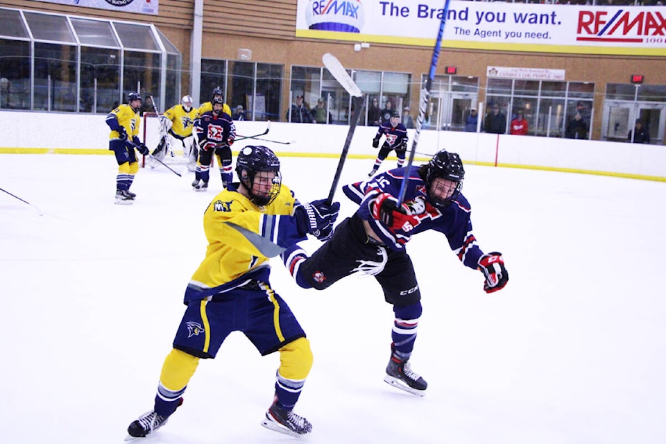 100 Mile House Wrangler Curtis Roorda and Sicamous Eagle Roan Girard collide during a game at the South Cariboo Rec Centre. (Patrick Davies photo - 100 Mile Free Press)