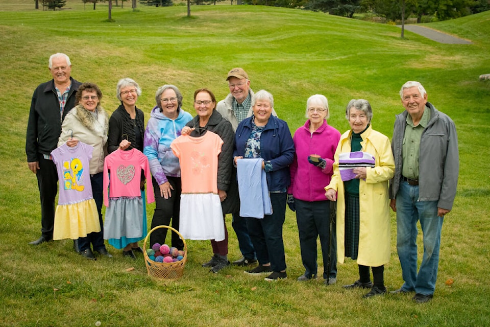 Volunteers for Canadian Food For Children hold up some of the items they make and have shipped overseas to families in need. (Jesse Madden Photograph)