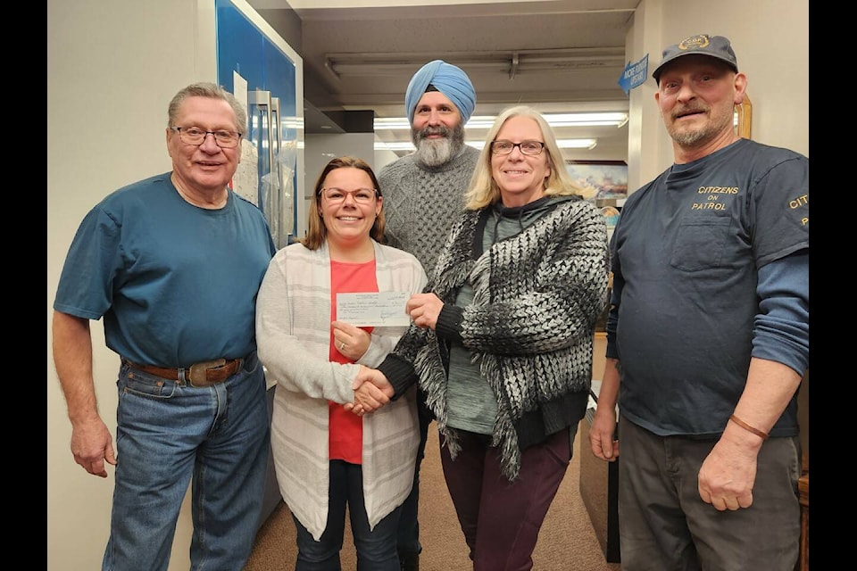Ric Northcott, Community Policing, left, Bob Sunner, Community Policing, Deb Pickering, Operation Red Nose coordinator, and Neil Sukert, Citizens on Patrol, present Sue Voth,Cariboo Chilcotin Youth Fiddlers, second from left, with a cheque. (Photo submitted)