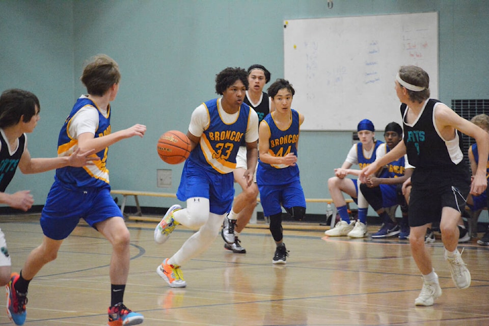 Williams Lake Broncos player Tyresse Alridge moves down the court with Jensen Bauerochse to his left and Jaskeerat Bagga to his right. (Monica Lamb-Yorski photo - Williams Lake Tribune)
