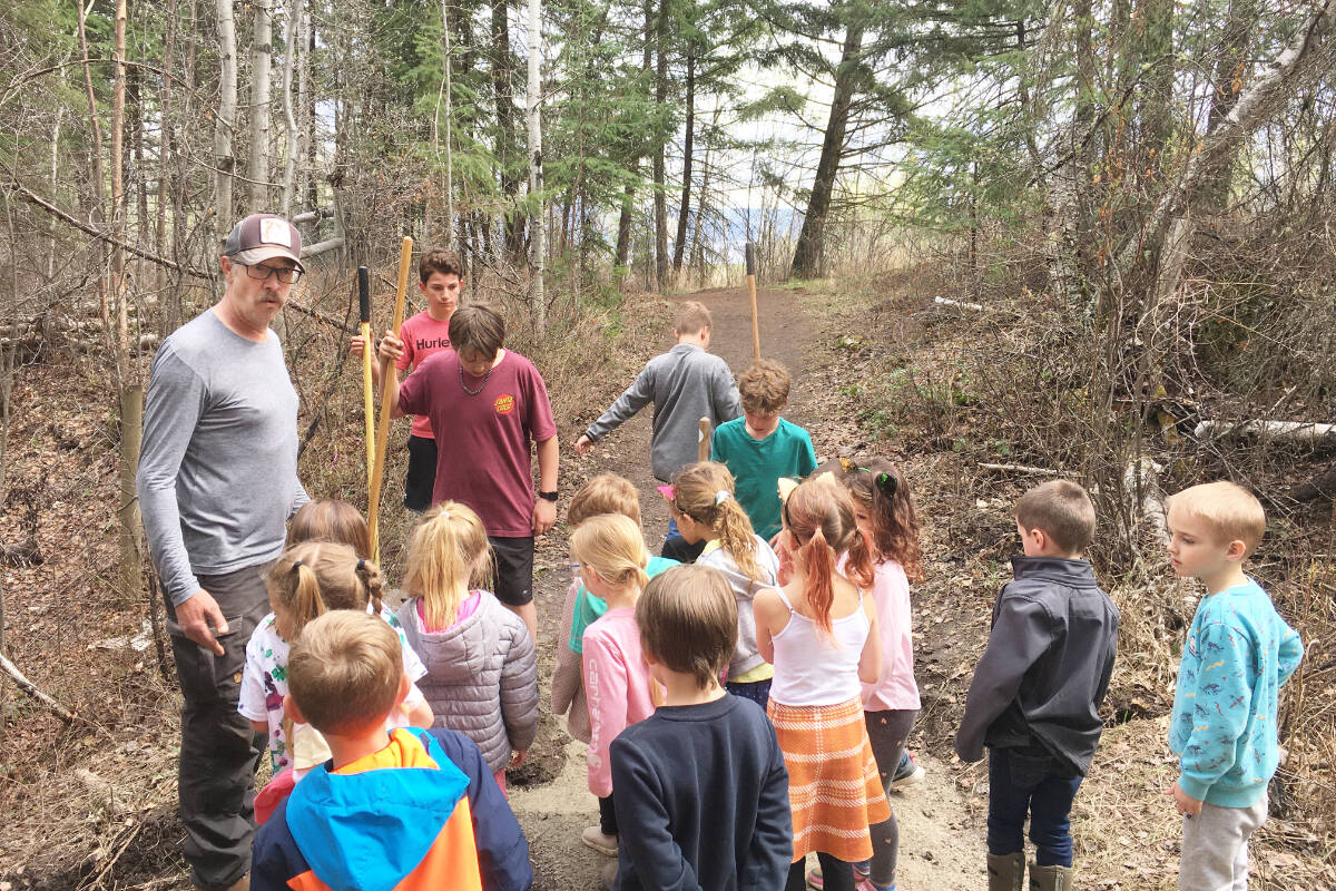 Tom Schoen, top left, takes some Chilcotin Road Elementary students out to see trail work in progress being done by fellow students on May 1, 2023. (Jane Wellburn photo)