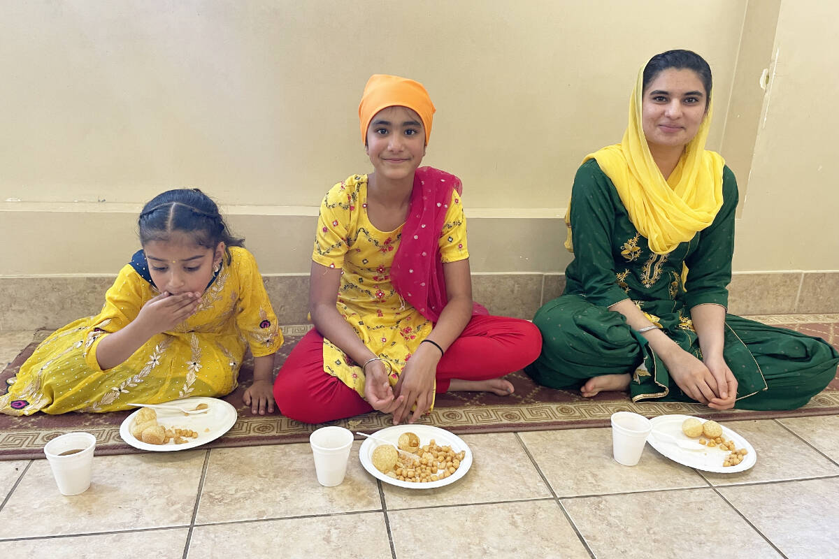 Harmandeep Kaur, from left, Reet Kaur Sidhu, and Noor Kaur Basi, were enjoying some of the food during Vaisakhi celebrations at Gurdwara Sahib Western Singh Sabha Association on May 13, 2023. (Ruth Lloyd photo Efteen)