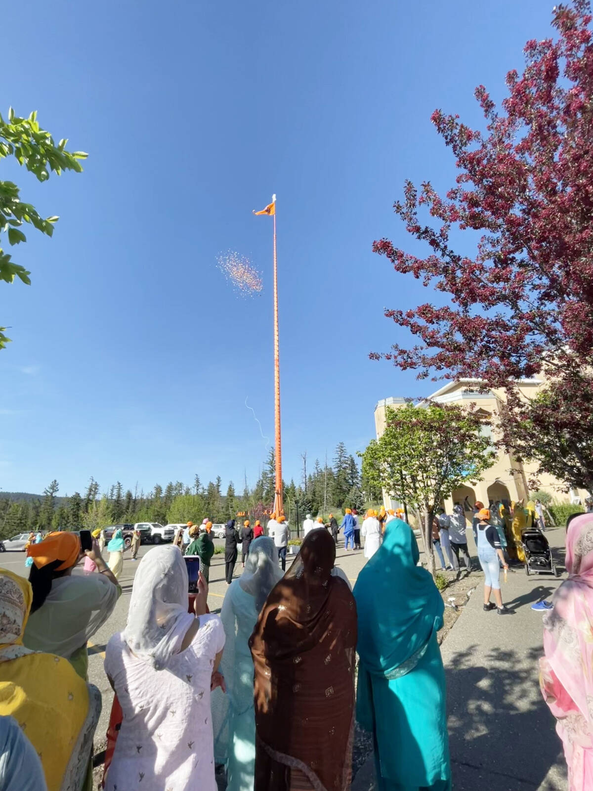 Onlookers watch as flower petals are released from the raised flag during Vaisakhi celebrations at Gurdwara Sahib Western Singh Sabha Association on May 13, 2023. (Ruth Lloyd photo Efteen)