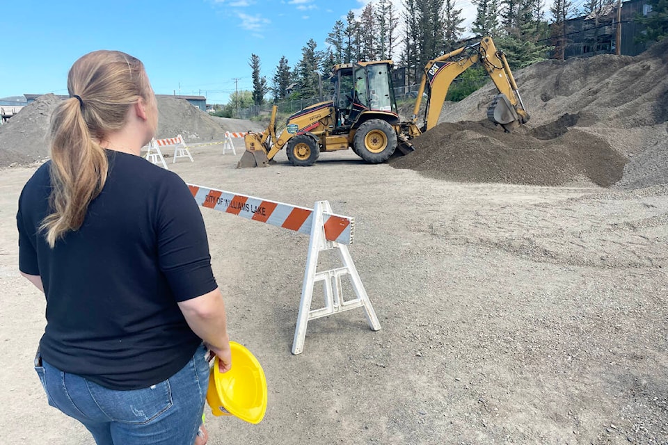 Caitlin Sabatino watches as her daughter gives operating a backhoe a try at the Williams Lake Public Works open house on May 27. (Ruth Lloyd photo - Efteen)