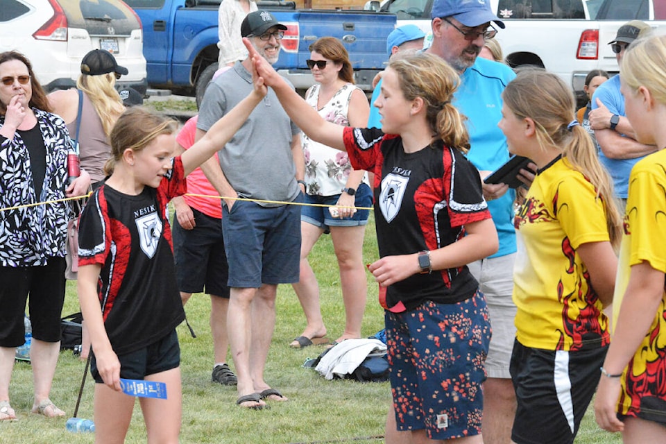 Nesika Elementary students Lily Reedman and Emmeline Therriault give each other a high-five after winning in the 100 m finals. (Monica Lamb-Yorski photo - Efteen)