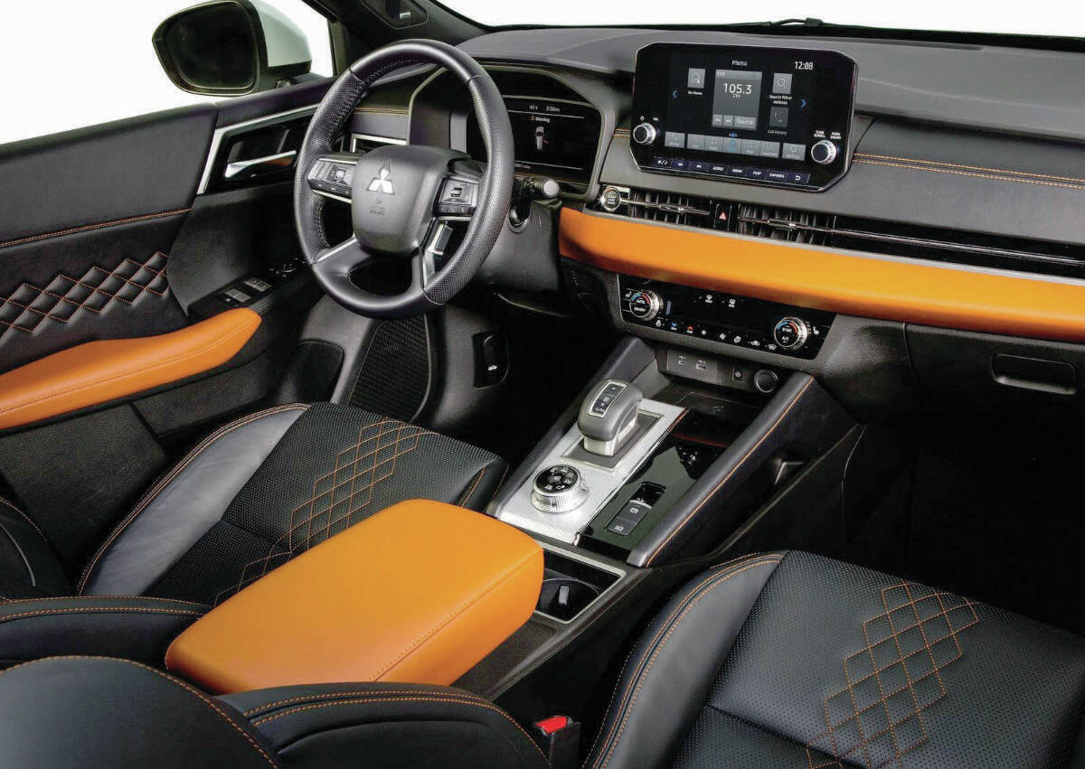 The Outlander PHEVs dash has a wide swath of open space to the right of the touch-screen. To change directions, the nifty shifter (both the Toyota and the Mitsubishi have continuously variable transmissions) slides forward or backward. PHOTO: MITSUBISHI