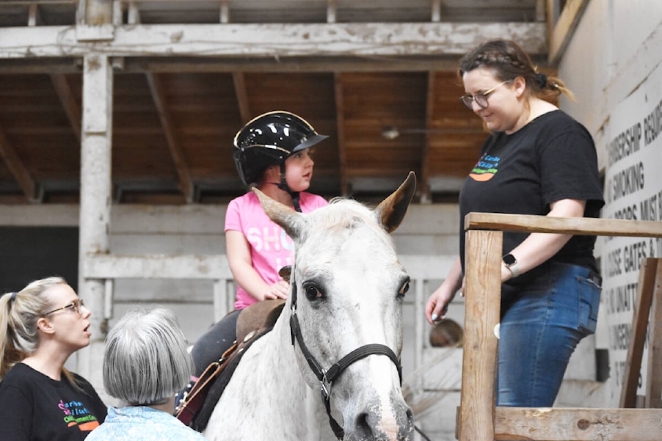 Kinslee Shoults prepares to dismount with the help of Makenna Morey. (Monica Lamb-Yorski photo - Williams Lake Tribune)