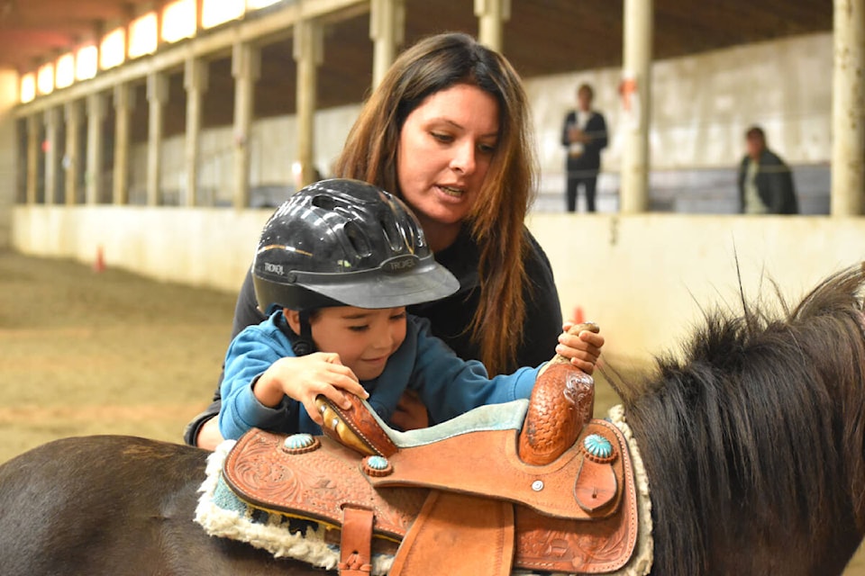 Handler Bobby Denner helps rider Ira George onto miniature horse during Horsin’ Around in the Cariboo Friday, July 14. (Monica Lamb-Yorski photo - Efteen)