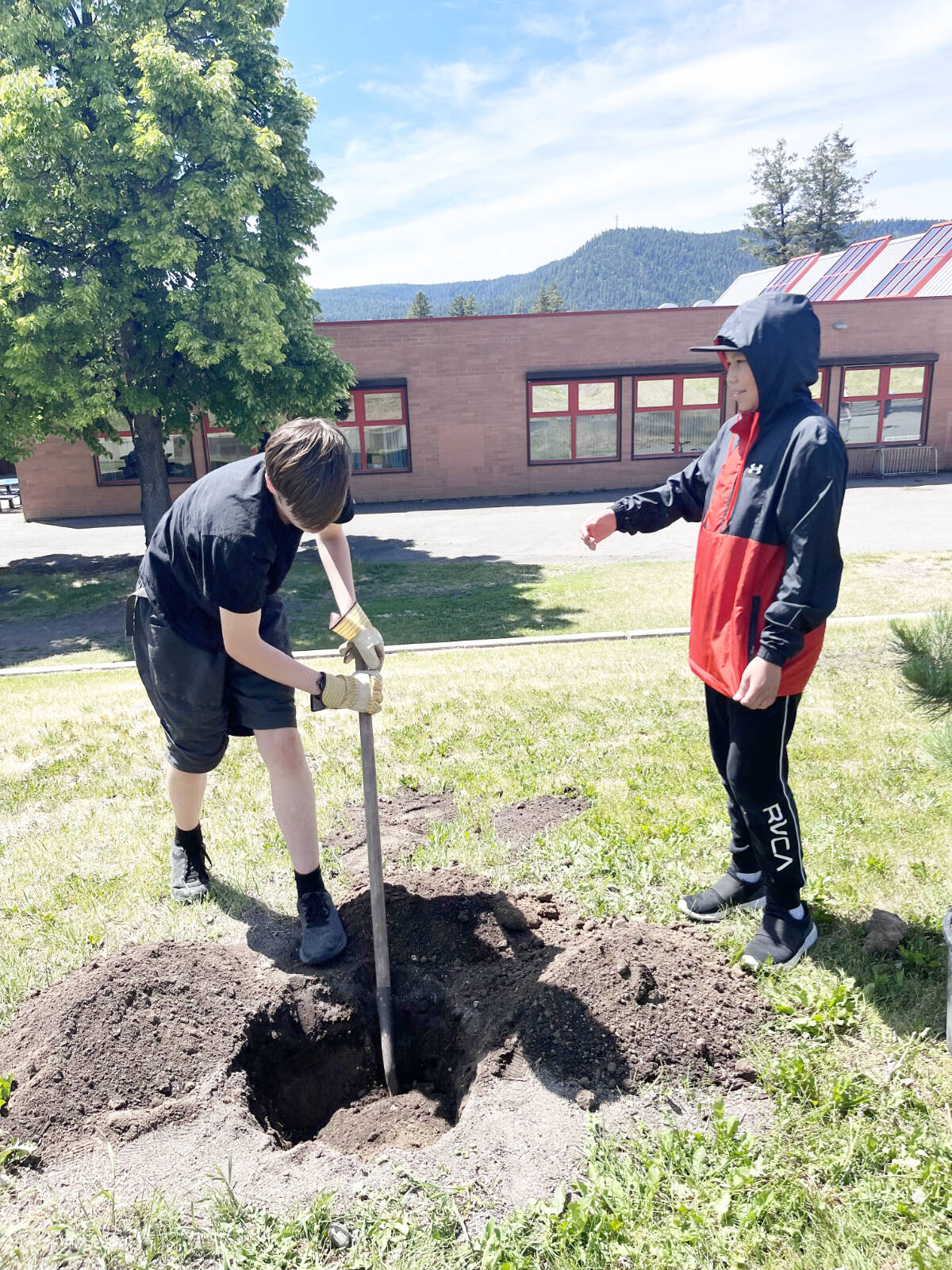 George Froom, left, and Drayton Alphonse prepare a hole for a tree in front of Columneetza. (Frances McCoubrey photo)