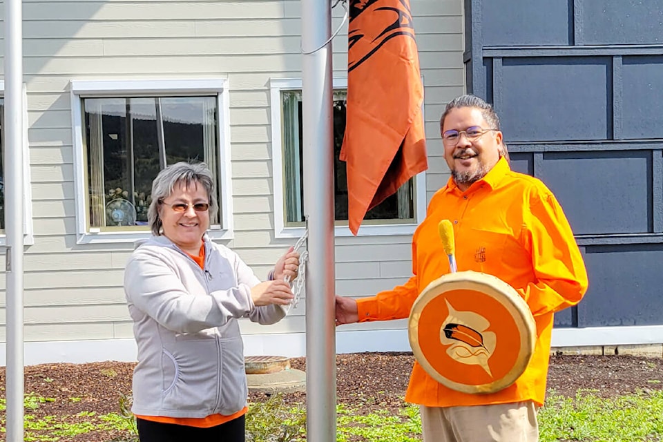 Phyllis Webstad, founder of Orange Shirt Day, left, and Michael Moses, acting mayor, raised an Every Child Matters flag at Williams Lake city hall on Sept. 6. (city of Williams Lake photo)