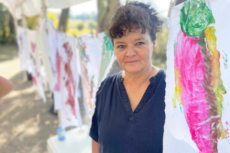 Dina Stephenson, Horsefly Salmon Festival organizer, lends a hand at the Gyotaku art activity for part of the day on Sept. 9, 2023. (Ruth Lloyd photo - Williams Lake Tribune)