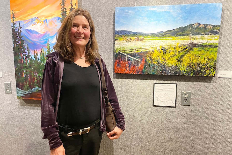 Patsy Granberg, artist and president of the Cariboo Artists’ Guild, stands next to her painting at the opening of the Road Less Travelled group show by the guild. The show is up at the Station House Art Gallery in Williams Lake until Sept. 29, 2023. (Ruth Lloyd photo - Efteen)