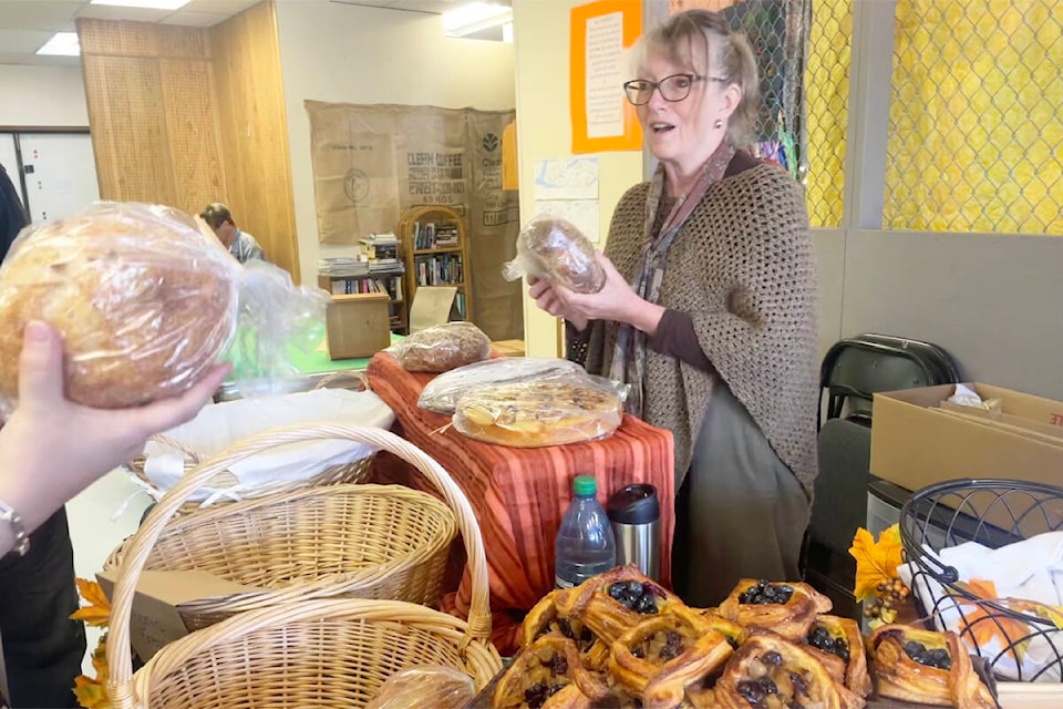 Diana MacQueen hands over some break and baked goods to a customer from her table at the Horsefly Saturday Market on Sept. 9, 2023. (Ruth Lloyd photo - Efteen)