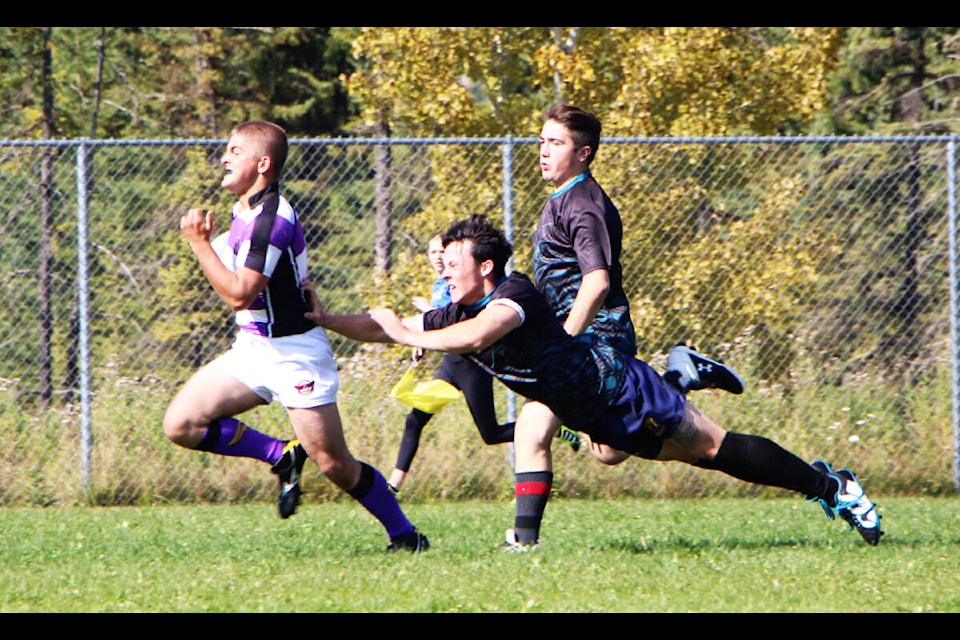 As an LCSS Falcon player runs for the endzone PSO Eagle Leo Kozier attempts a flying tackle during a game of rugby. (Patrick Davies photo - 100 Mile Free Press)