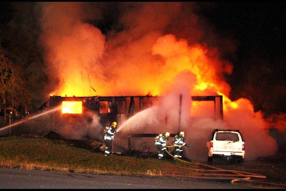 100 Mile Fire Rescue works to extinguish a house fire on Scott Road on the night of Friday, Sept. 29. The fire fully consumed the home though the occupants, a family of four, were able to escape unharmed. The cause of the fire is under investigation. (Patrick Davies photo - 100 Mile Free Press)