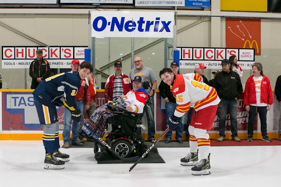 Mustangs alumni Dave Chapell drops the ceremonial puck with the Wranglers and Mustangs captains during a retro alumni game Saturday, Oct. 19 in Williams Lake. 