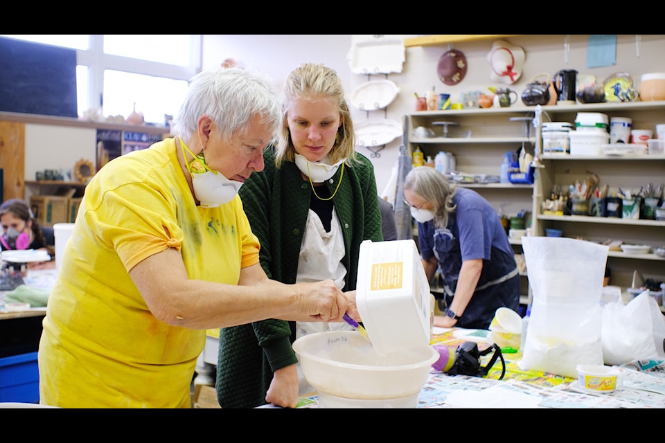 Lesley Lloyd (left) helping Breanna Froese (right) during a Potters' Guild workshop on how to make glazes.