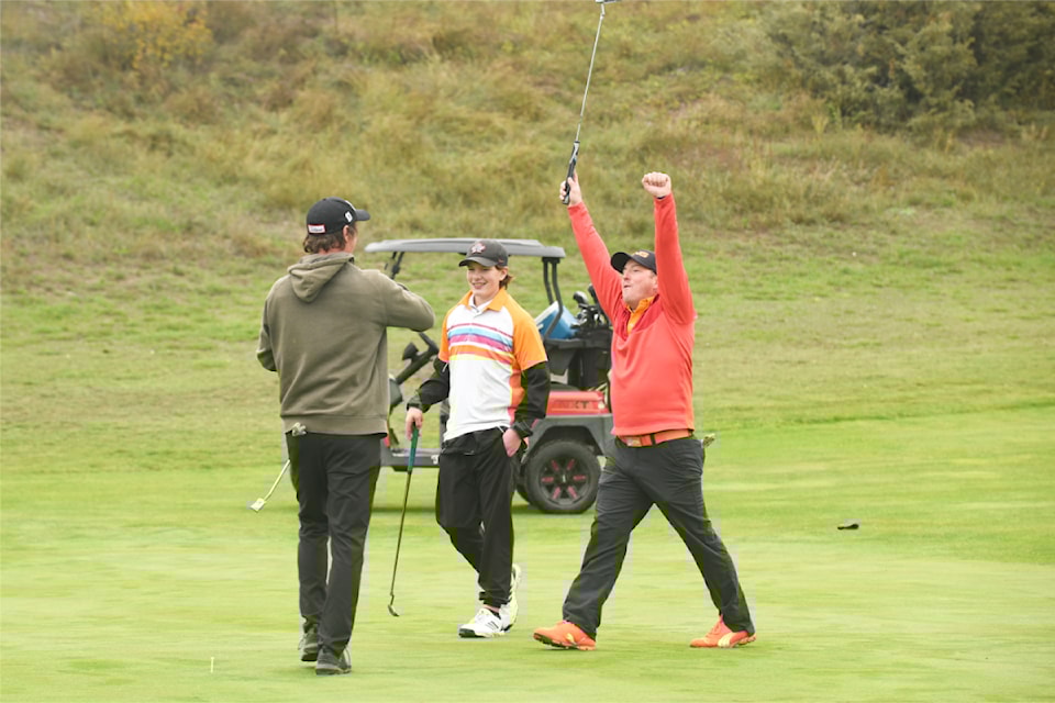 Matt Stewart (from right) and Austin Johnston celebrate teammate Kurt Bannerman's successful putt at the Every Child Matters fundraiser golf tournament at Coyote Rock on Sept. 28.