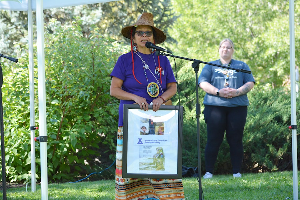 During International Overdose Awareness Day in Williams Lake, Carrie Phillips holds a framed poster dedicated to her late daughter who died from the toxic drug crisis in 2018. 