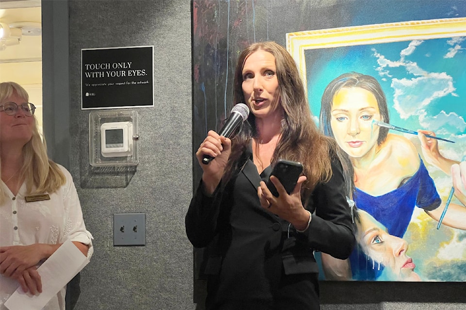 Tiffany Jorgensen, centre, speaks at the opening reception of her art show at the Station House Gallery in Williams Lake.