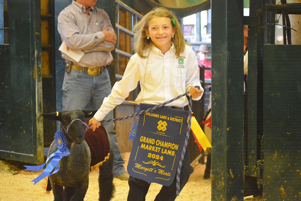 Kaycee Cunningham is all smiles during the Parade of Champions as she leads her grand champion market lamb. 