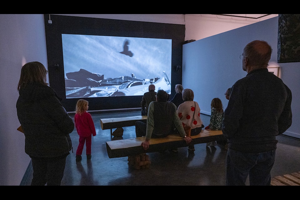 People watch a film in David Curtis's new exhibit, Land Mass, during the opening reception at the Yukon Arts Centre on Nov. 28. (Mike Thomas/Yukon Arts Centre)