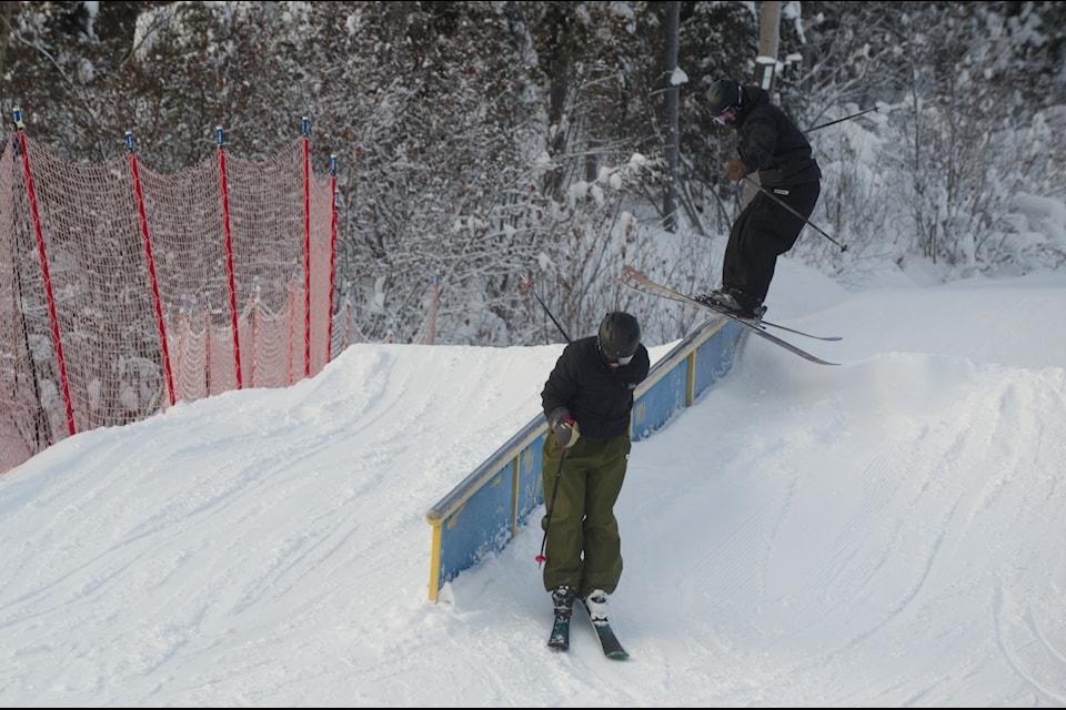 During practice sessions on Dec. 4, two skiers perform back-to-back grinds on an obstacle set up for the Slopestyle competition. (Jake Howarth/Yukon News.
