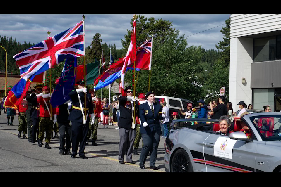 Yukon Commissioner Adeline leads the 2024 Canada Day parade down Whitehorse's Main Street from the back seat of a muscle car.
