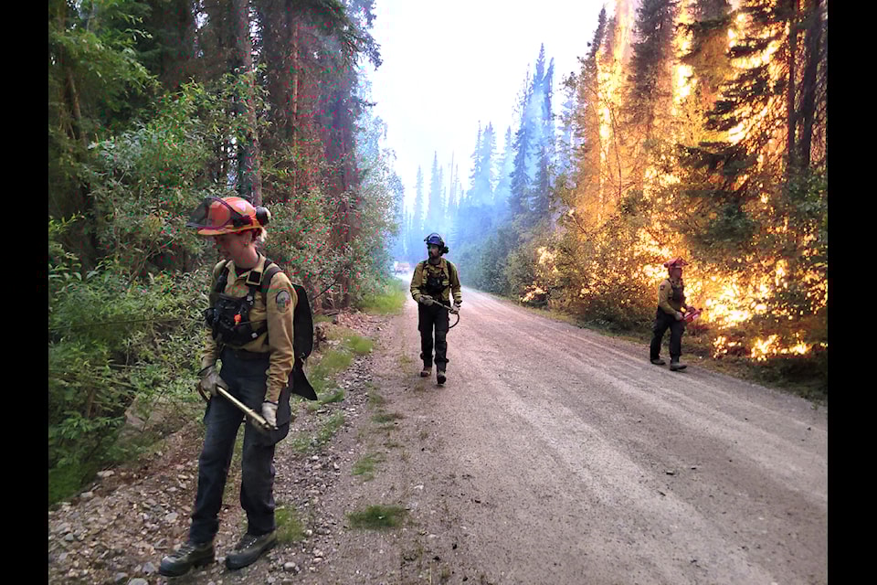 Firefighters patrol for spot fires with water packs during an June 30 ignition operation along Minto Lake Road. (Yukon government/submitted)