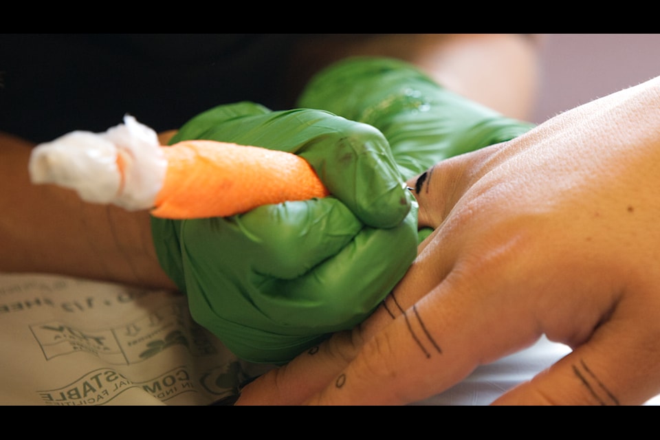 Anne Spice tattoos Olivia Gatensby's hands at the Kwanlin Dün First Nation health centre on Tuesday, June 18. 