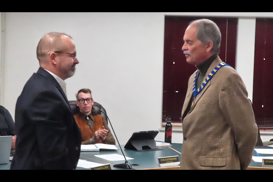 Dawson CAO David Henderson presents the chain of office to Mayor Stephen Johnson. (Dan Davidson Photo)