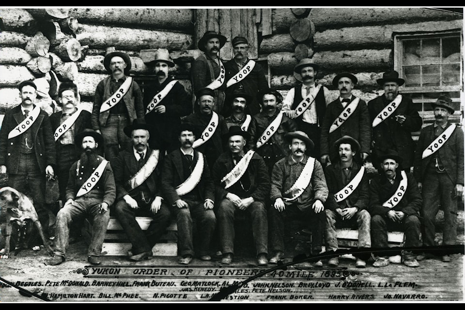 Thought to be the earliest group photo of the Yukon Order of Pioneers, this was taken at Forty Mile the summer of 1895.  Each member is  wearing his YOOP sash from his left shoulder (in all subsequent photos , sashes are hung from the right shoulder). At the time, the sashes were fabricated by women who were living in Forty Mile. (The Dawson Museum)
