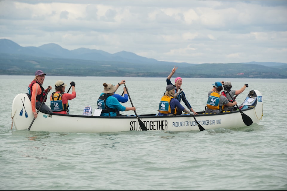 Yukoners, Carolyn Relf, Cheryl Rivest, Gillian Smith, Krista Mroz, Natalie Haltrich, Tiera Naber, Chantelle Rivest and Alex Bouchard paddling through Lake Laberge for Yukoners' Cancer Care Fund. (Jake Howarth/Yukon News)