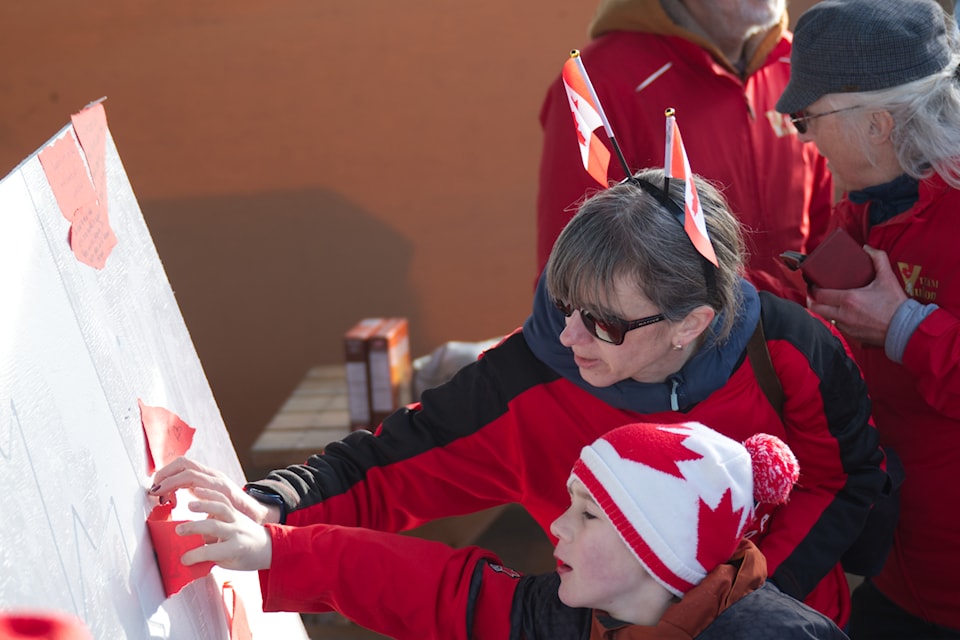 Attendees at a March 27 parade down the Whitehorse waterfront plastered a wood cut Canadian flag with hopeful and inspiring messages. (Jim Elliot/Yukon News)
