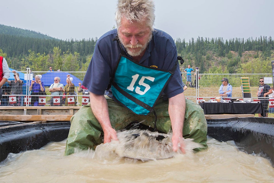 Local gold miner Henry Reinink shakes his pan of dirt in water during the Yukon Gold Panning Championships in Dawson City in 2018. (Crystal Schick/Yukon News)