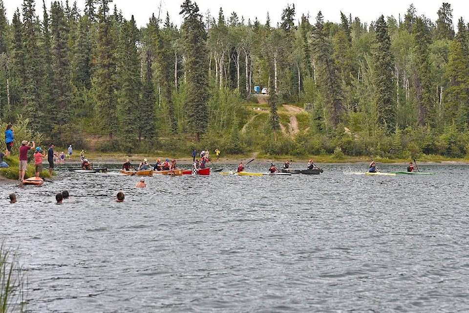 Paddlers start the Long Lake Paddle Cross on July 18 as spectators and swimmers look on. (John Hopkins-Hill/Yukon News)