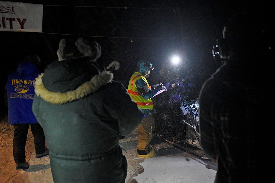 Michelle Phillips goes through her mandatory checks after arriving at the Circle checkpoint in the early hours of Feb. 3 during the 2020 Yukon Quest. (John Hopkins-Hill/Yukon News)