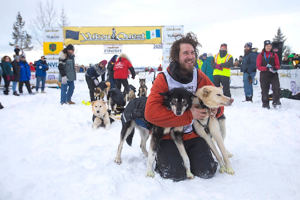 Brent Sass poses with his lead dogs after crossing the finish line in Whitehorse on Feb. 11 to win his third Yukon Quest. (Crystal Schick/Yukon News)