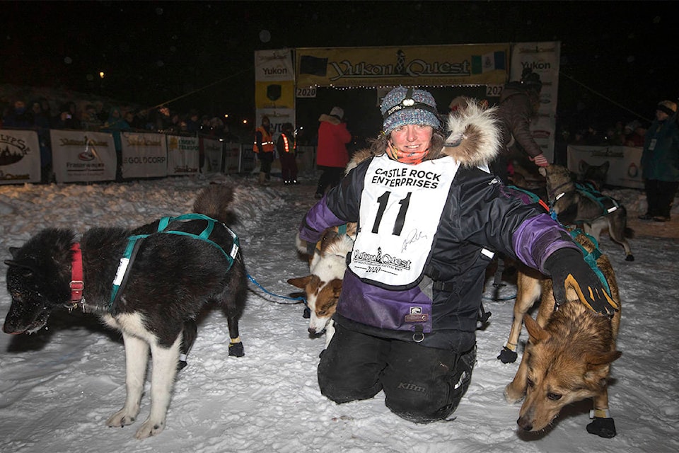 Yukon musher Michelle Phillips poses with her dogs after finishing the Yukon Quest in second place in Whitehorse on Feb. 11. (Crystal Schick/Yukon News)