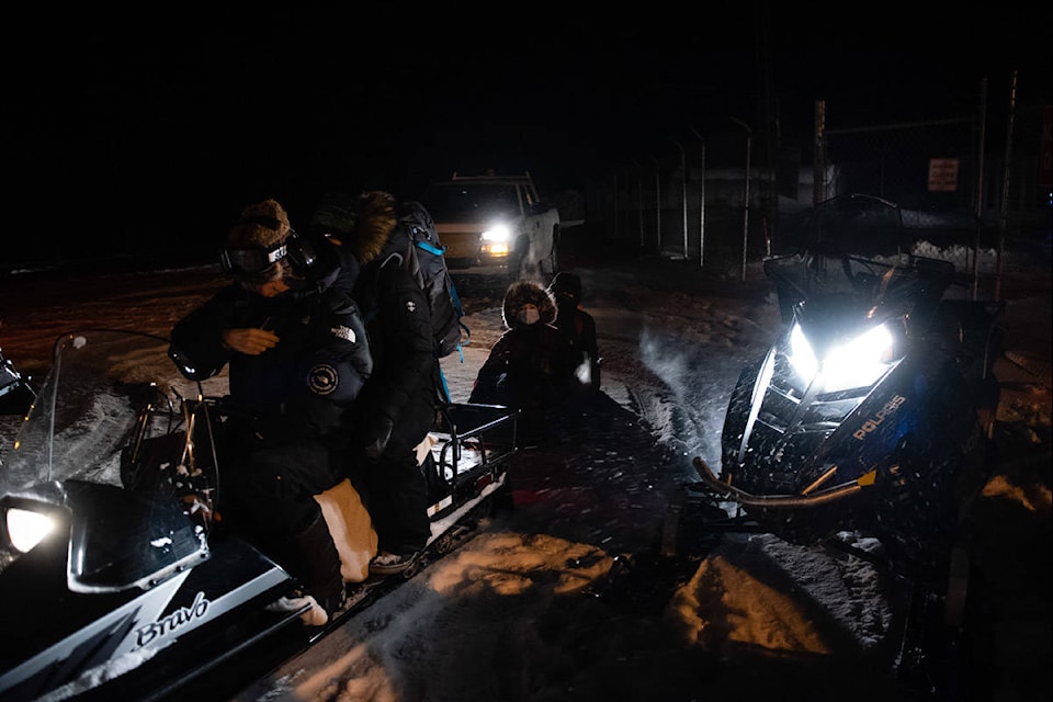 Team Togo member Katie Moen sits in a sled behind a snowmobile for the ride from the airport to Chief Zzeh Gittlit School. (Haley Ritchie/Yukon News)