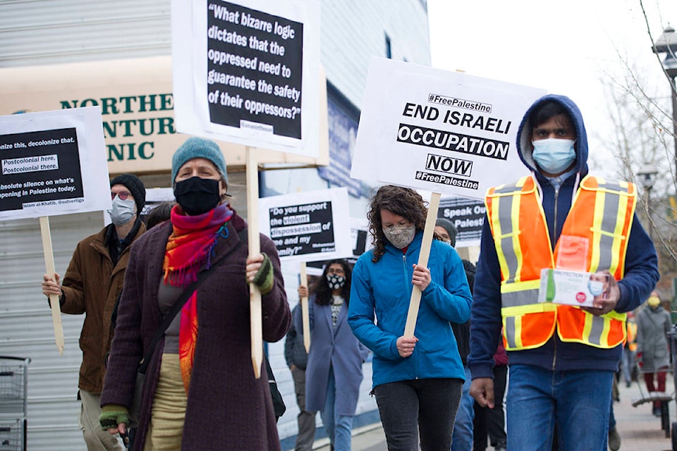 Demonstrators march down Main Street in Whitehorse on May 21. (Haley Ritchie/Yukon News)