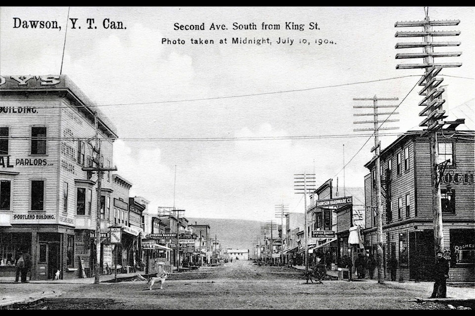 Even at midnight, there are plenty of men -and dogs - visible in this post card photo from Smith’s Book Store, of Second Avenue in Dawson City in 1904. (Courtesy/Gates Collection)