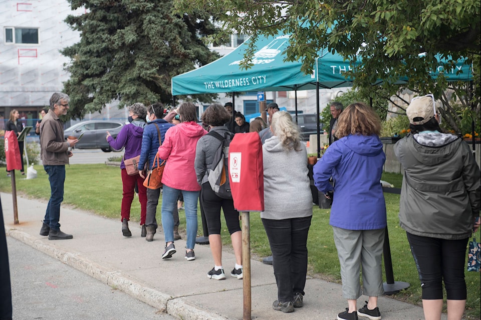 People wait for a seedling from the Martha Black Mayday tree outside city hall on Aug. 26. (John Tonin/Yukon News)