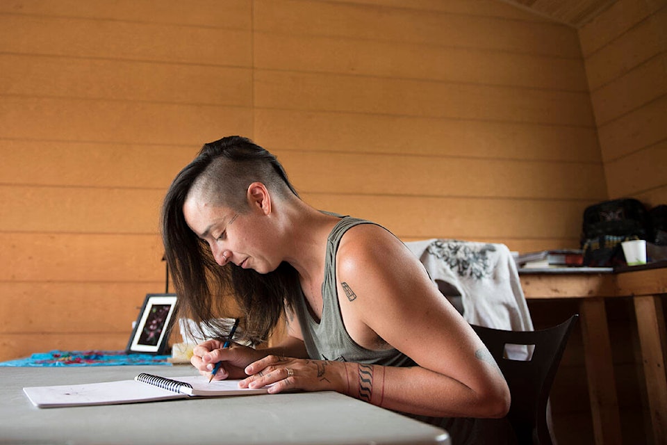 Artist Anne Spice draws in her studio at the Kwanlin Dün Cultural Centre in Whitehorse on August 2. Spice spent three weeks in the Yukon as a 2021 Shakaat Artist-in-Residence. (Haley Ritchie/Yukon News)