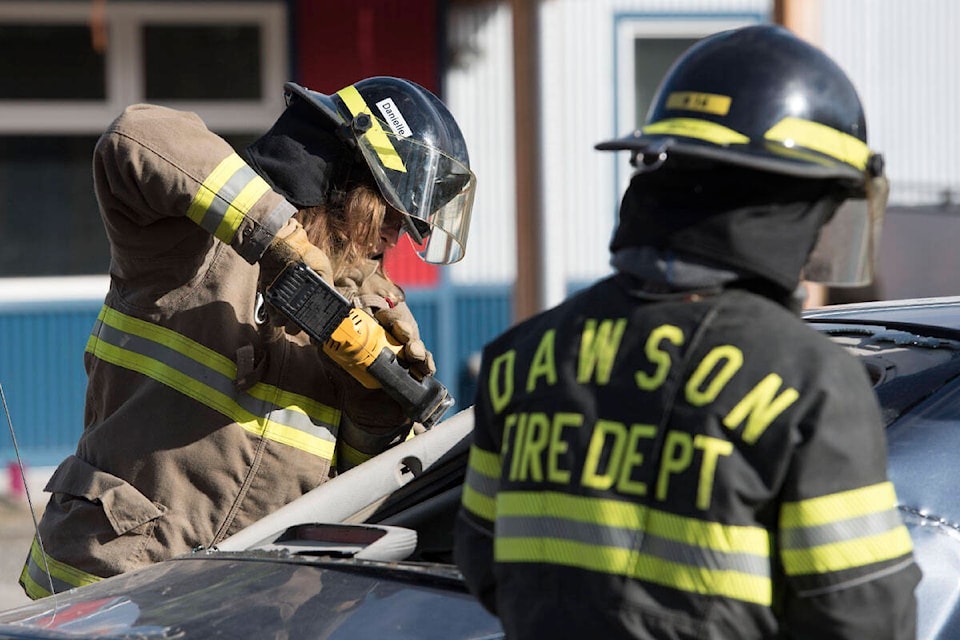 Danielle Koop cuts through part of a vehicle during Ember training in Whitehorse on September 9. (Haley Ritchie/Yukon News)