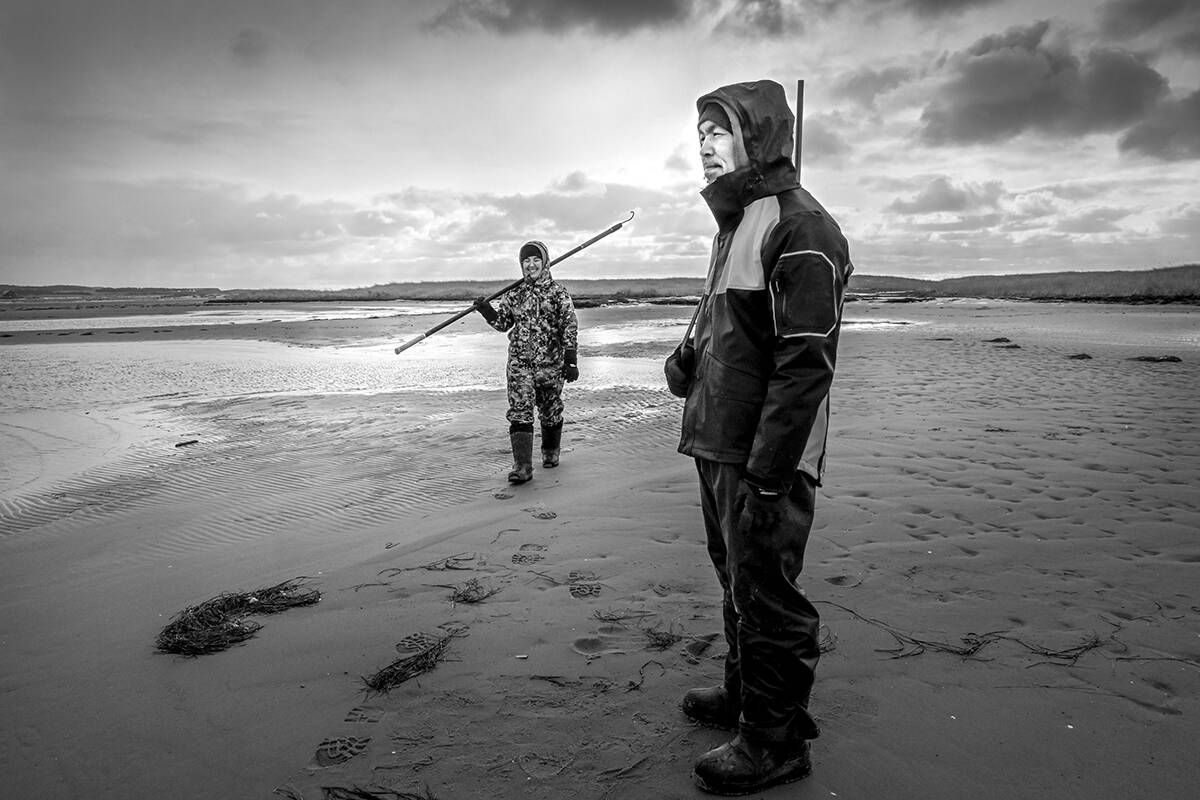 Shouldering a hakapik, Aija Komangapik, left, walked the beach with Philip Anguratsiaq during a seal hunting trip in November 2021. Photo courtesy of Yoanis Menge