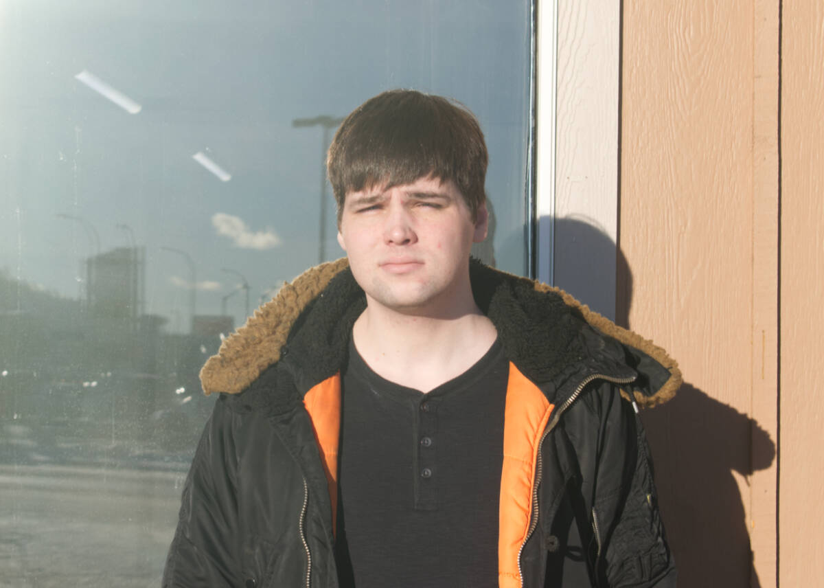 Stephen Grant stops for a photo outside the Stop In Family Hotel on Jan. 26, 2023. (Dana Hatherly/Yukon News)