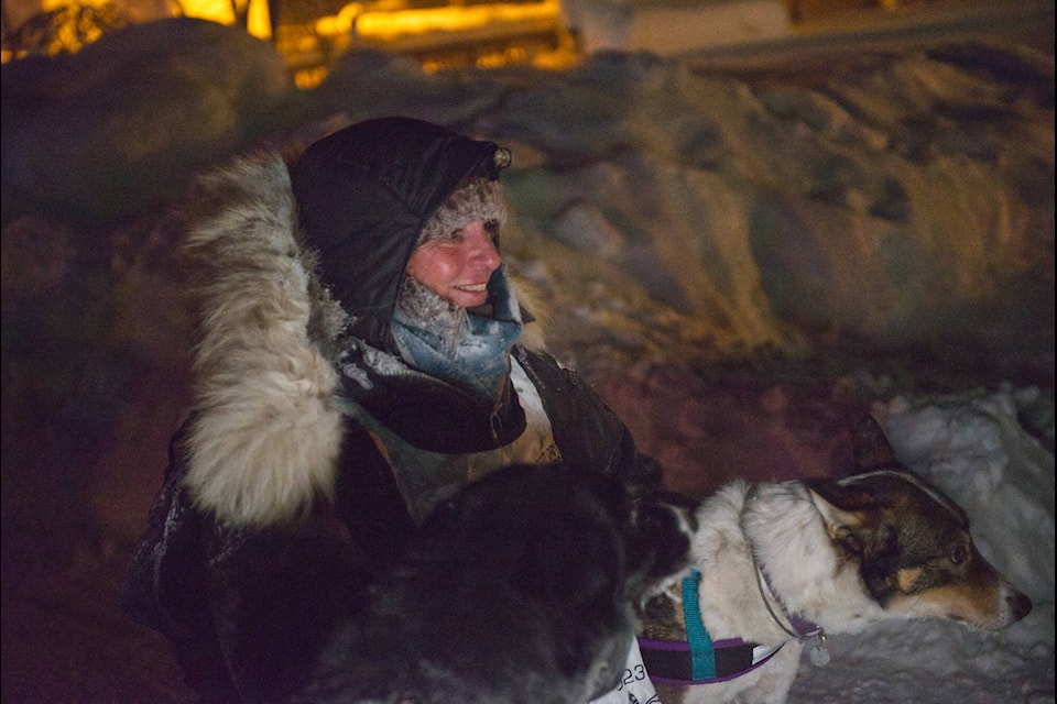 Michelle Phillips scratches lead dogs Lambo and Cleo behind the ears after finishing the 450-Mile Yukon Quest Race to Dawson City. (Jim Elliot/Yukon News)